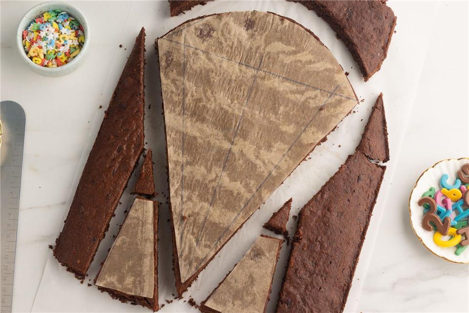 Zur Einschulung: Wie wär’s mit einer essbaren Schultüte? Ein klassischer Schokokuchen auf einem Blech mit Backrahmen ist die Basis für den Schultütenkuchen. Die zuvor gezeichneten Vorlagen auf Backpapier werden dann darauf gelegt und an den Rändern entlang zugeschnitten. Mutige können natürlich auch ohne Vorlage frei Hand zuschneiden. Kathrin Runge/backenmachtgluecklich.de/dpa-tmn