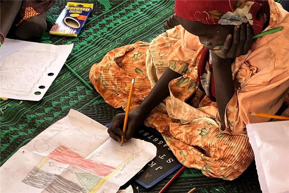 Ein kleines Mädchen malt die sudanesische Flagge.Eva Krafczyk/dpa