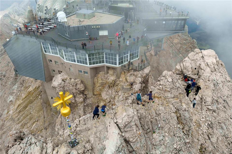 Ein schmaler Grat führt zum Gipfel der Zugspitze mi dem berühmten vergoldeten Kreuz. Peter Kneffel/dpa