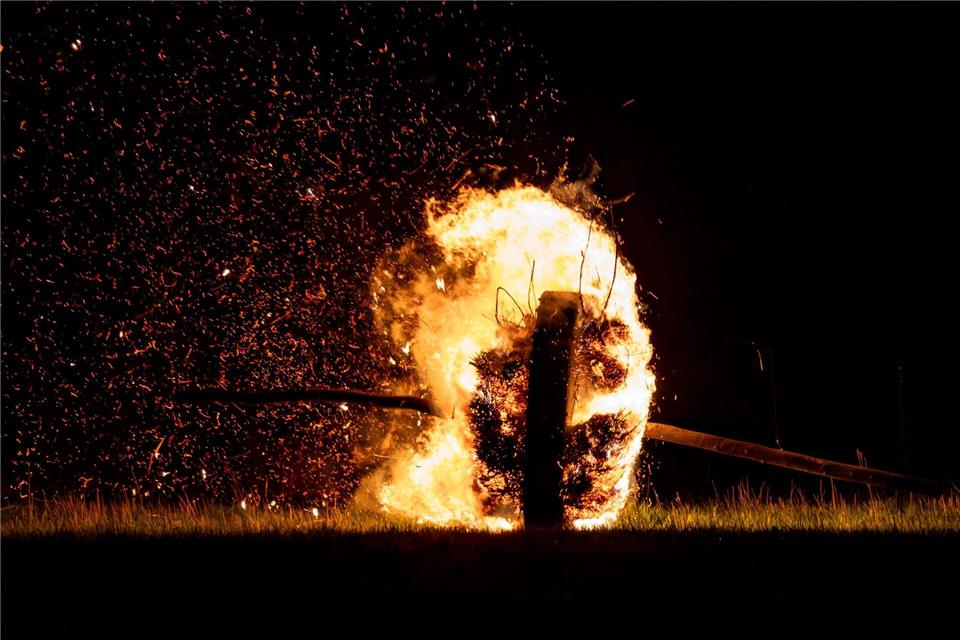 Ein sogenanntes Osterrad läuft, hier im vergangenen Jahr, brennend einen Hügel herunter und zieht eine Feuerspur hinter sich her. (Archivbild)Christoph Reichwein/dpa