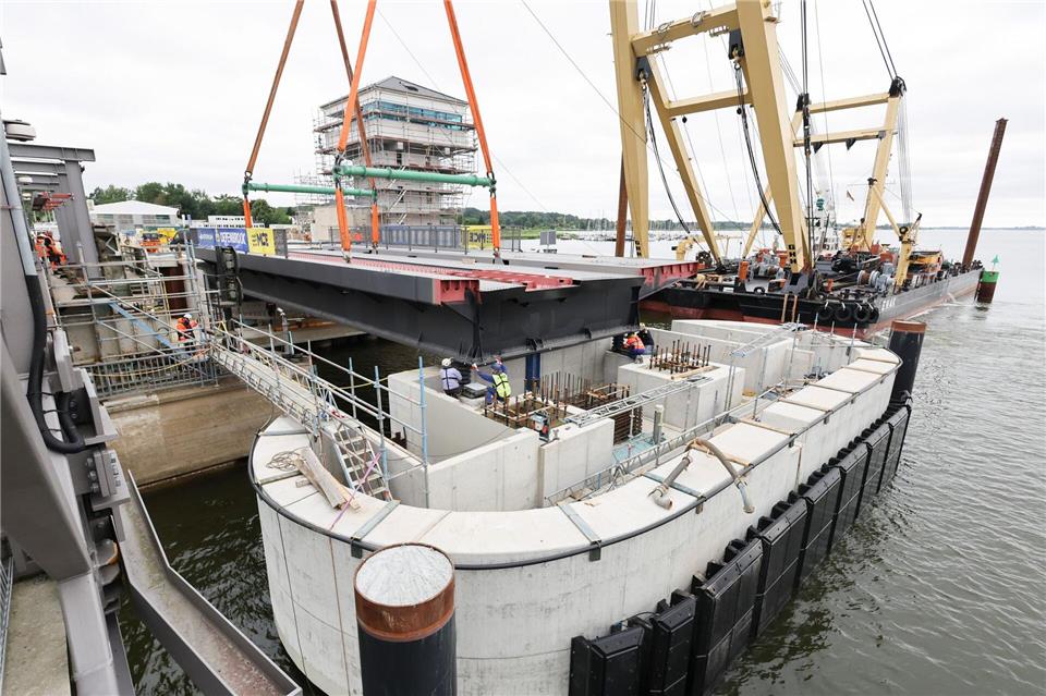 Ein wichtiges Stück der neuen Brücke wird vom Schwimmkran an die richtige Position gehoben.Christian Charisius/dpa