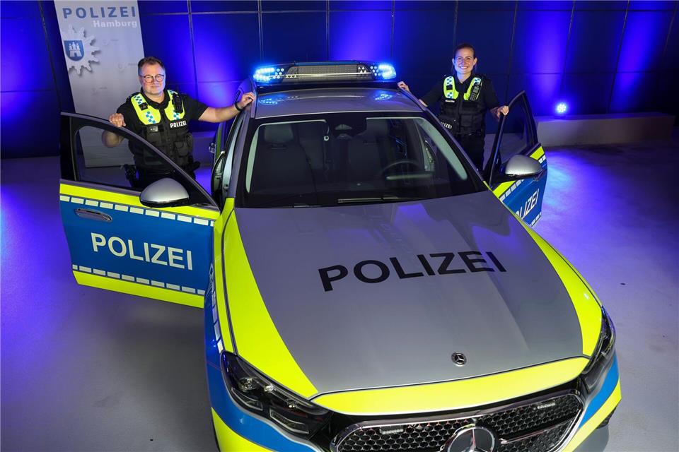 Eine Beamtin und ein Beamter der Polizei Hamburg stehen vor einem Streifenwagen mit dem neuen „Präsenzlicht“Christian Charisius/dpa
