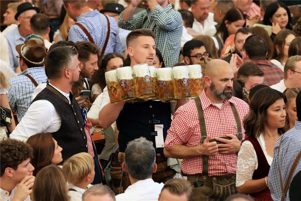 190. Oktoberfest: „Gegen die Krisen der Welt“ Eine Bedienung schleppt Maßkrüge durch ein Wiesn-Festzelt.Karl-Josef Hildenbrand/dpa