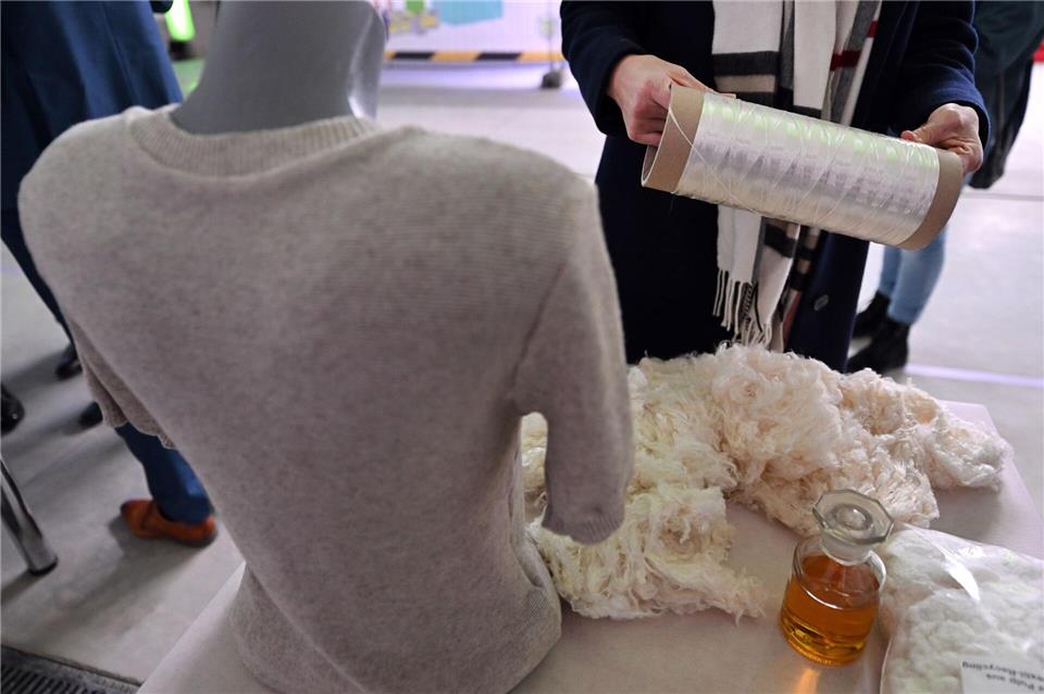 Eine Besucherin betrachtet Fasern aus Baumwolltextil-Recycling während der Einweihung des „Demonstration and Innovation Center for Textile Circular Economy“ (DICE), einem Thüringer Innovationszentrum mit Schwerpunkt textile Kreislaufwirtschaft. Martin Schutt/dpa