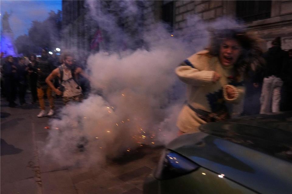 Eine Demonstrantin flieht vor Tränengas während während eines Protests für die Global Sumud Flottilla.Thibault Camus/AP/dpa