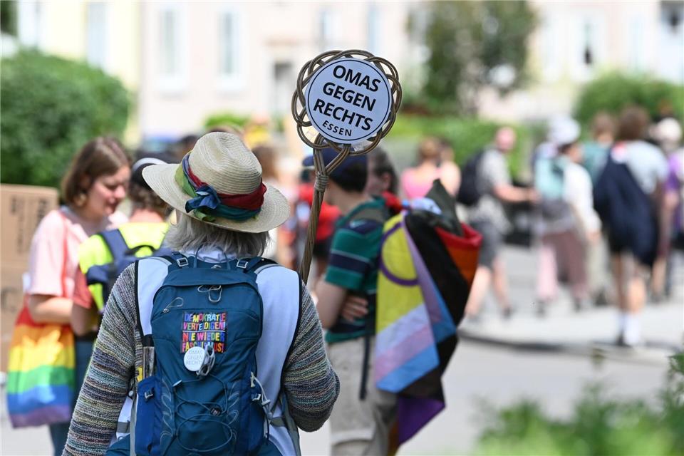 Eine Demonstrantin hält ein Schild von „Omas gegen Rechts“ in die Höhe.Heiko Rebsch/dpa