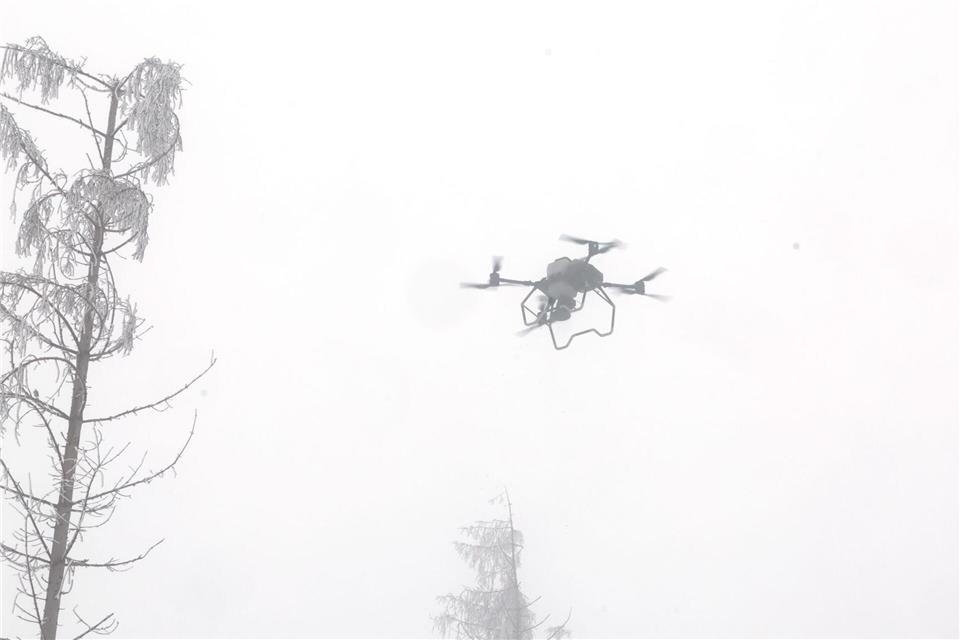 Eine Drohne sät bei Winterwetter Bäume auf der Saalfelder Höhe aus.Bodo Schackow/dpa