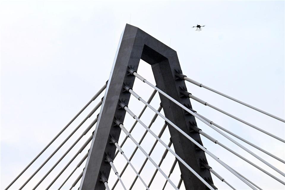 Eine Drohne steigt neben den Drahtseilen der Leverkusener Rheinbrücke auf, um den Zustand der Konstruktion zu überprüfen. Die Autobahnmeisterei sperrte die Autobahn 1 (A1) in beide Richtungen, nachdem sich über Nacht Eis gebildet hatte, das auf darunter fahrende Fahrzeuge hätte stürzen können.Roberto Pfeil/dpa