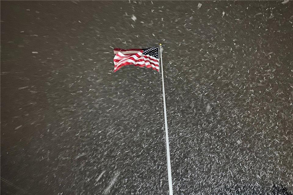 Eine Flagge weht im Wind, während in Lowville in den USA Schnee fällt.Cara Anna/AP/dpa