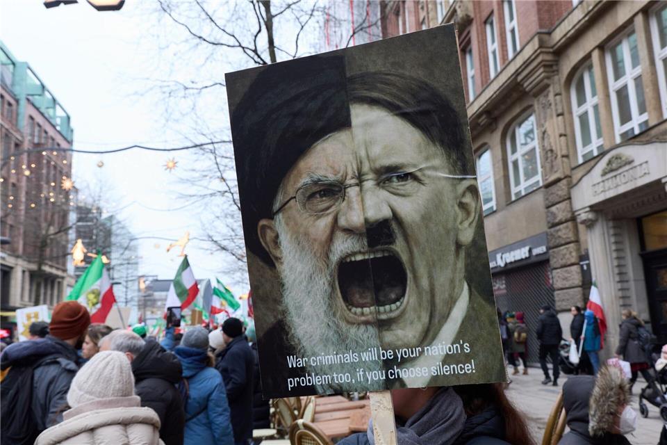 Eine Fotomontage kombiniert das Gesicht des obersten iranischen Führers, Ajatollah Ali Chamenei, mit dem von Adolf Hitler.Georg Wendt/dpa