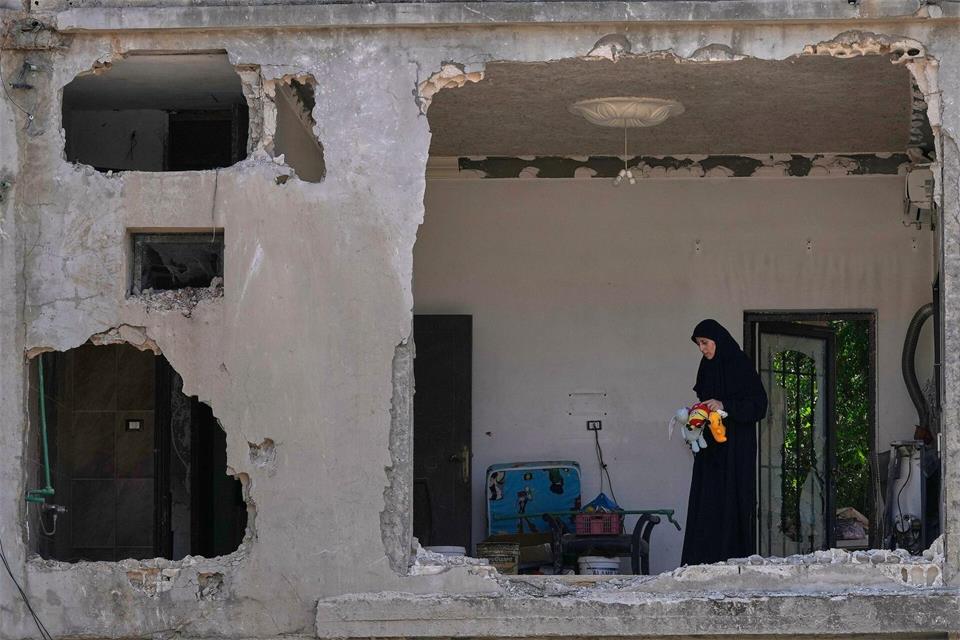 Eine Frau begutachtet ihr beschädigtes Haus an der Stelle einen Tag nach einem israelischen Luftangriff im Dorf Arab Salim im Südlibanon.Mohammed Zaatari/AP/dpa