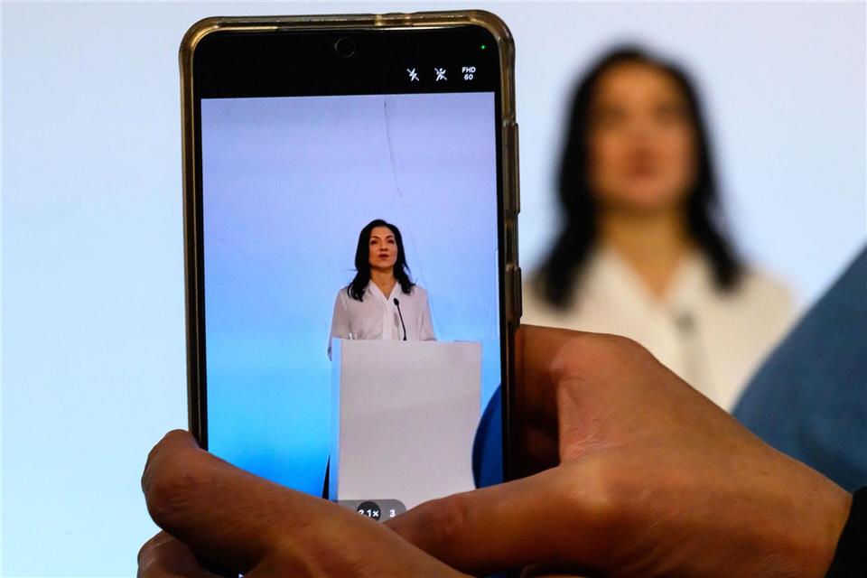 Eine Frau filmt mit ihrem Smartphone das Statement von Bundeswirtschaftsministerin Katherina Reiche (CDU) bei der Regionalpolitischen Jahrestagung in Chemnitz. Hendrik Schmidt/dpa