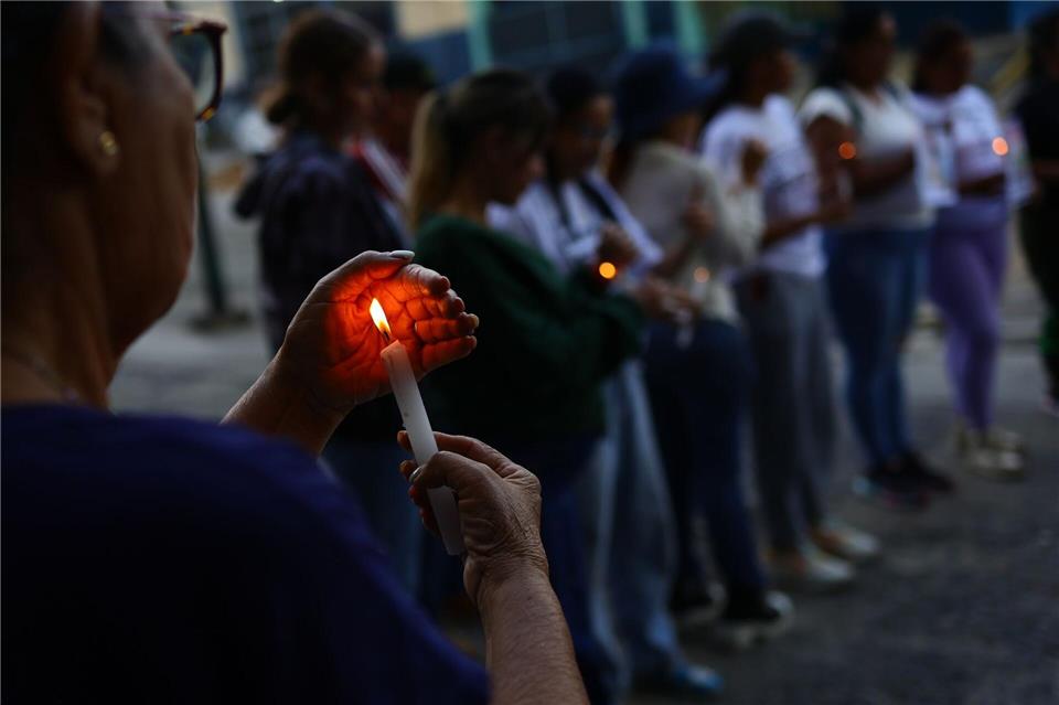 Eine Frau hält eine Kerze bei einer Demonstration für die Freilassung von politischen Gefangenen in der Nähe des Gefängnisses El Helicoide in Caracas.Javier Campos/dpa