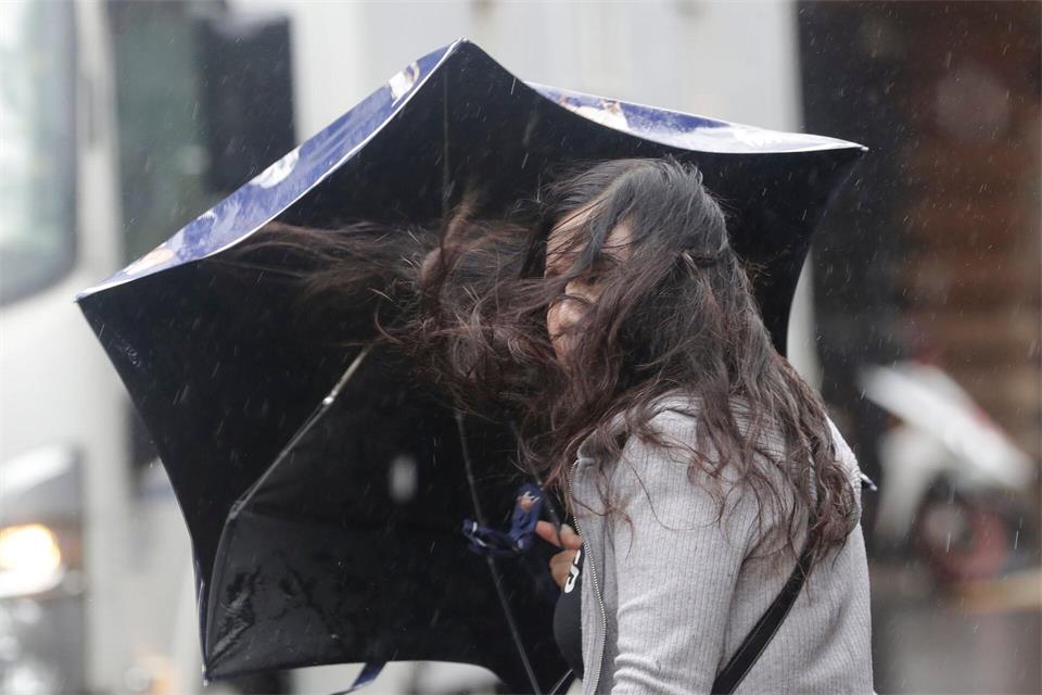 Eine Frau kämpft gegen die vom Taifun Champi verursachten Windböen in Taipeh.Chiang Ying-ying/AP/dpa