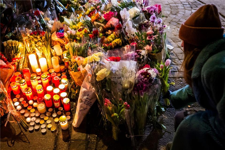 Eine Frau legt Blumen in der Nähe des Ortes nieder, an dem während der Neujahrsfeierlichkeiten in der Bar und Lounge „Le Constellation“ in Crans-Montana ein Brand ausgebrochen war, der Todesopfer und Verletzte forderte.Jean-Christophe Bott/KEYSTONE/dpa