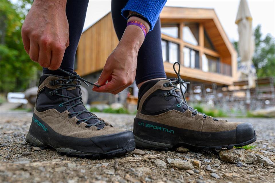 Eine Frau schnürt ihre Wanderschuhe. Deutschland gilt mit seinen vielfältigen Landschaften und Regionen als Wanderland. Hendrik Schmidt/dpa