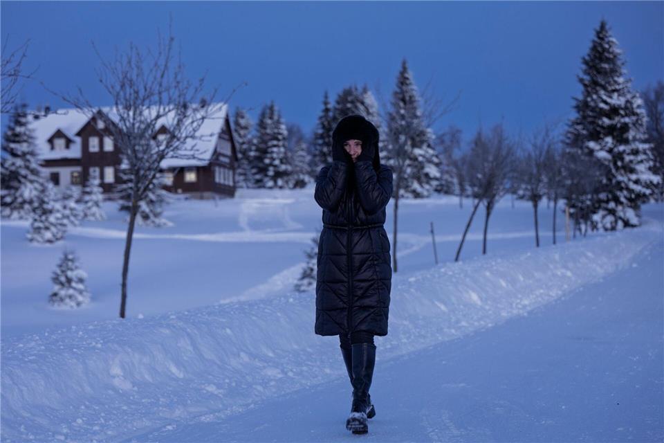 Eine Frau spaziert durch eine verschneite Landschaft in Tschechien.Radek Petrá·ek/CTK/dpa