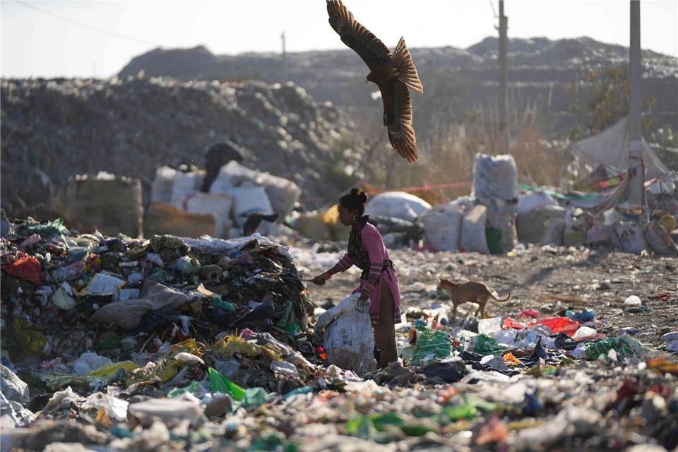 Eine Frau sucht auf einer Mülldeponie im indischen Jammu nach etwas Verwertbarem.Channi Anand/AP/dpa