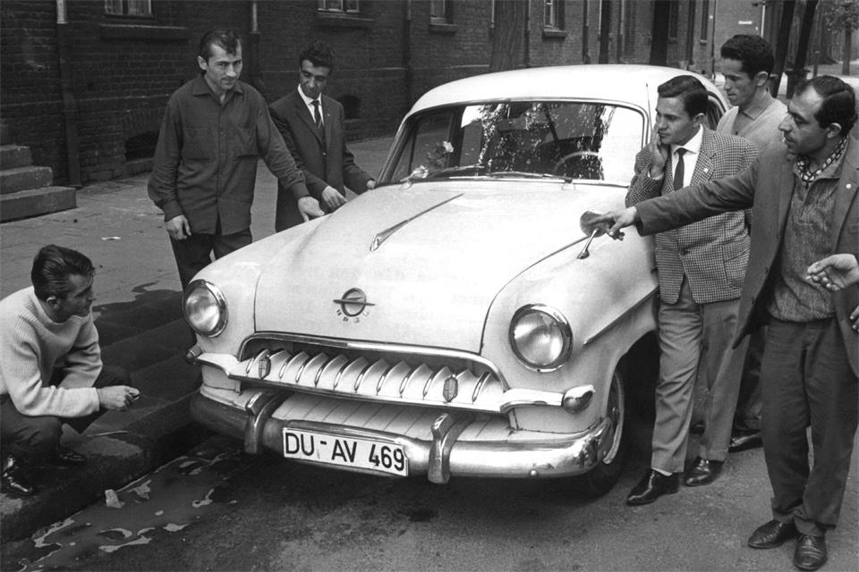 Eine Gruppe türkischer Gastarbeiter bewundert im Juli 1962 im Ruhrgebiet den neuerworbenen Wagen eines Landsmannes (Archivbild). picture alliance / dpa