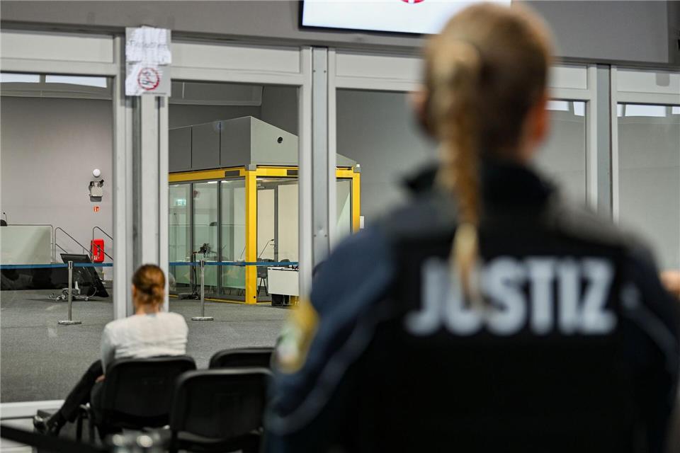 Eine Justizbeamtin steht vor dem Verhandlungssaal im temporären Gerichtsgebäude des Landgerichtes Magdeburg.Heiko Rebsch/dpa