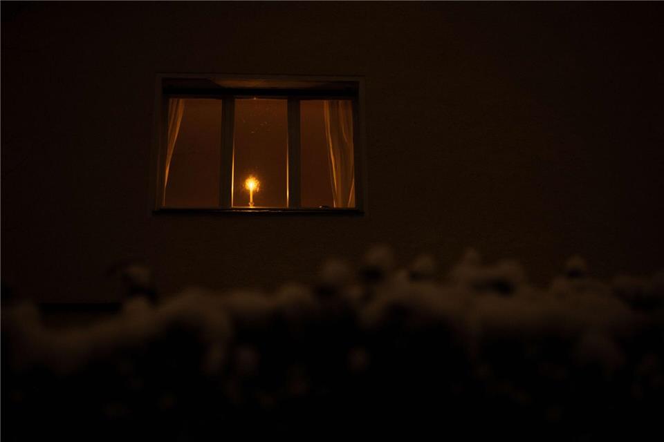 Eine Kerze leuchtet während eines Stromausfalls im Südwesten Berlins in einem Mehrfamilienhaus. Hilfe kommt auch aus NRW.Carsten Koall/dpa