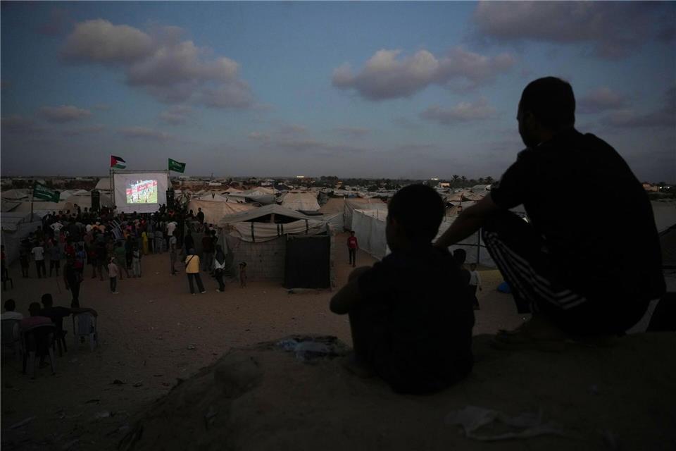 Eine Leinwand mitten im Gazastreifen: Palästinenser verfolgen die Live-Übertragung des Fußball-WM-Spiels zwischen Spanien und Saudi-Arabien.Abdel Kareem Hana/AP/dpa
