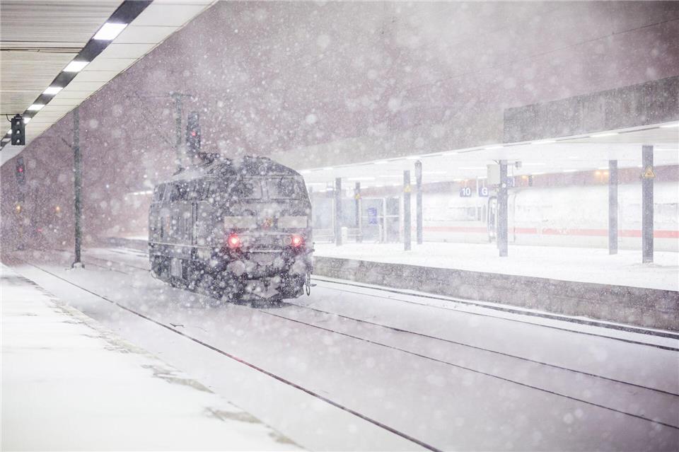 Eine Lok steht am frühen Morgen an einem verschneiten Gleis im Hauptbahnhof Hannover. Moritz Frankenberg/dpa