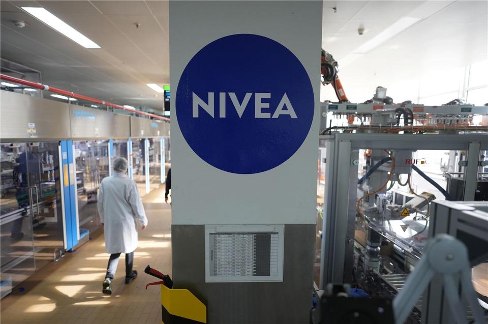 Beiersdorf senkt erneut Umsatzprognose Eine Mitarbeiterin geht in Hamburg durch eine Nivea-Produktionshalle. (Archivbild) Marcus Brandt/dpa