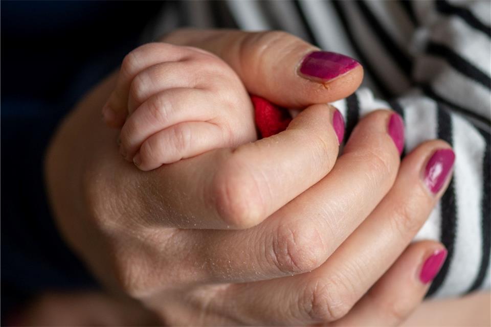Eine Mutter hält die Hand ihres Sohnes.