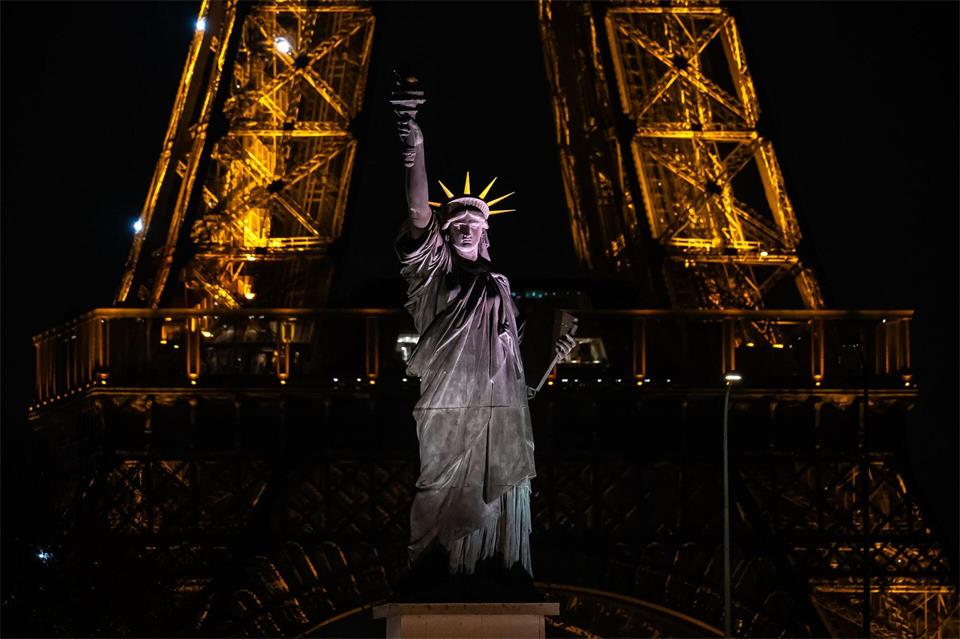 Eine Nachbildung der Freiheitsstatue steht vor dem Eiffelturm in Paris.Aurelien Morissard/AP/dpa