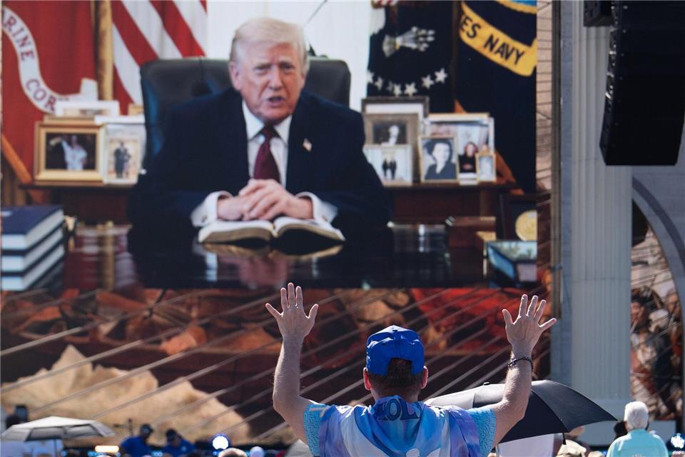 Eine Person betet, während eine aufgezeichnete Videobotschaft von US-Präsident Donald Trump abgespielt wird.Julia Demaree Nikhinson/AP/dpa