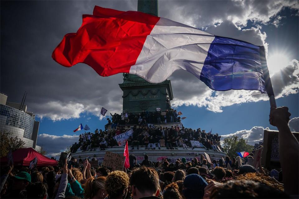 Eine Person hält bei einer Demonstration in Paris gegen unterfinanzierte Schulen eine französische Nationalfahne.Aurelien Morissard/AP/dpa