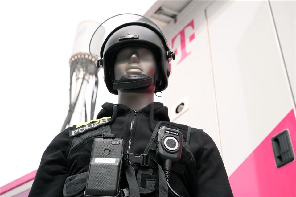 Eine Puppe in Polizei-Uniform zeigt, wie es gehen soll: An ihrer Uniform ist nicht nur ein Funkgerät, sondern auch ein Smartphone befestigt. Die Einsatzzentrale kann sich auf das Smartphone schalten und dank der Kamera sehen, was gerade los ist.Wolf von Dewitz/dpa