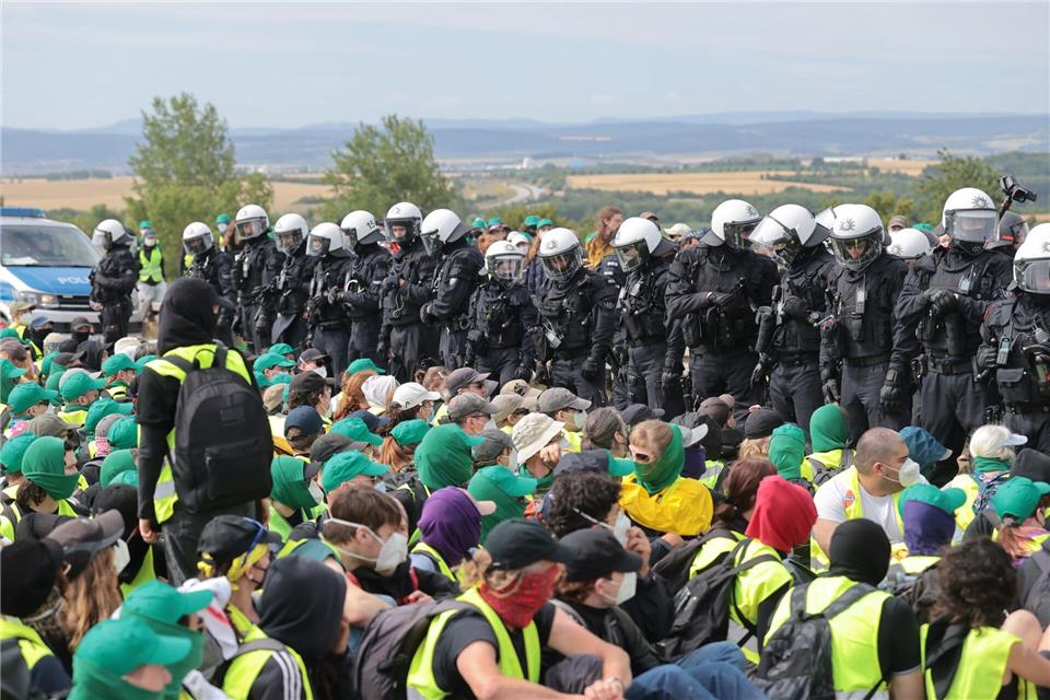 Eine Sitzblockade auf der Autobahn 71 - Polizisten umringen die Demonstranten.Michael Reichel/dpa