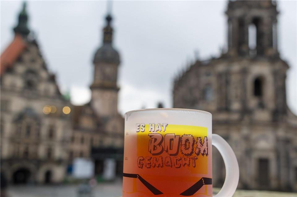 Eine Tasse mit der Aufschrift „Es hat Boom gemacht“ erinnert vor der Kulisse der Dresdner Altstadt an den Einsturz der Carolabrücke.Jürgen Lösel/dpa