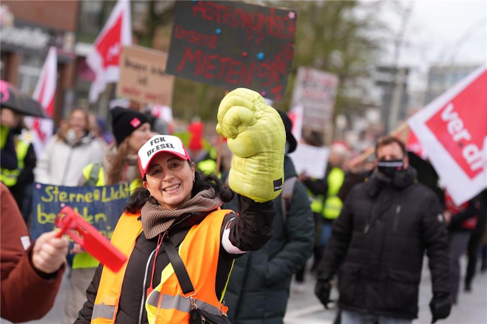 Eine Teilnehmerin der Kundgebung reckt einen übergroßen Handschuh in die Höhe. Marcus Brandt/dpa