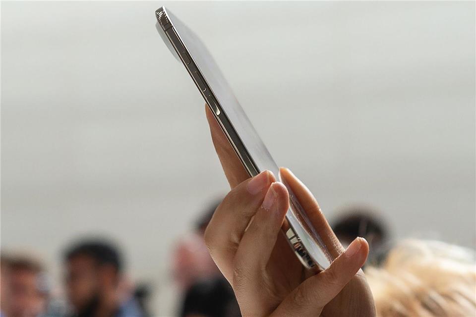 Eine Teilnehmerin der Vorstellung neuer iPhone-Modelle von Apple probiert das neue iPhone Air aus.Andrej Sokolow/dpa