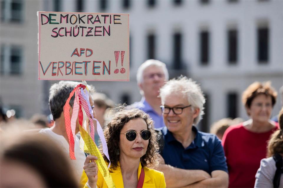 Eine Teilnehmerin hält ein Schild mit der Aufschrift „Demokratie schützen, AfD verbieten“.Christoph Soeder/dpa