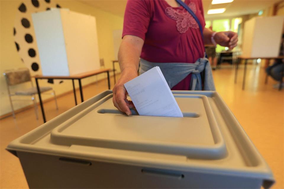 Eine Wählerin wirft in einem Wahllokal in Wernigerode ihren Stimmzettel in eine Wahlurne.Matthias Bein/dpa