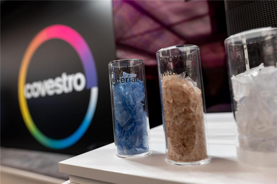 Eine deutsche Firma wird arabisch: Das Logo des Spezialchemie-Konzerns in einem Firmen-Showroom, davor Gläser mit Covestro-Materialien. Fabian Strauch/dpa