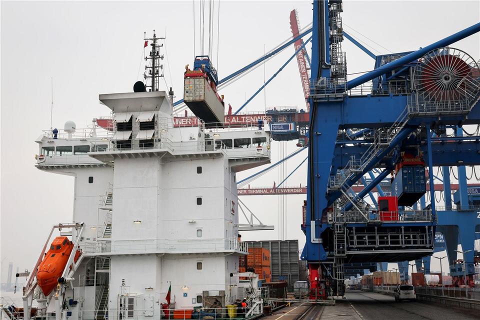 Eine ferngesteuerte Containerbrücke bewegt im Hamburger Hafen einen Seecontainer. Christian Charisius/dpa
