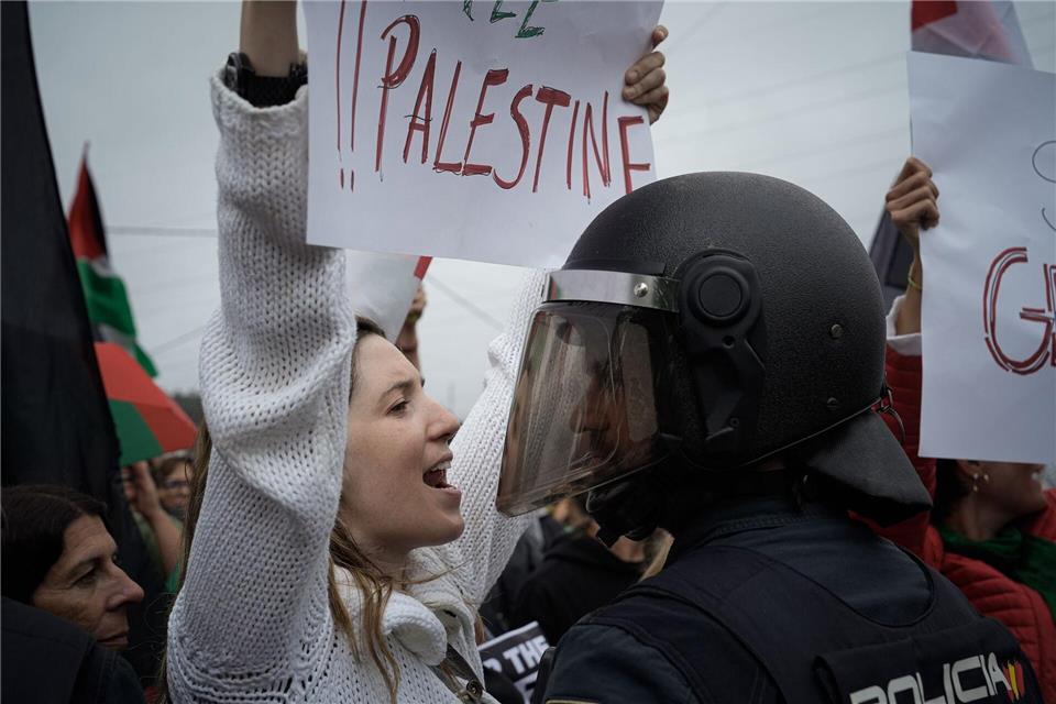 Eine junge Frau protestiert vor einem Polizisten während einer Kundgebung in Spanien bei der Vuelta a España gegen den Gaza-Krieg.Adrián Irago/EUROPA PRESS/dpa