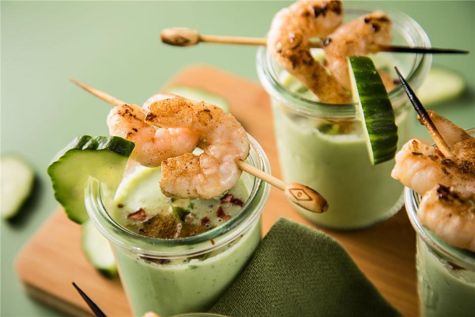 Eine kalte Suppe erfrischt an warmen Tagen - wie diese aus Gurken, Buttermilch und Basilikum, getoppt mit Garnelenspießen, Chiliflocken und Cayennepfeffer.picture alliance/dpa/dpa-tmn