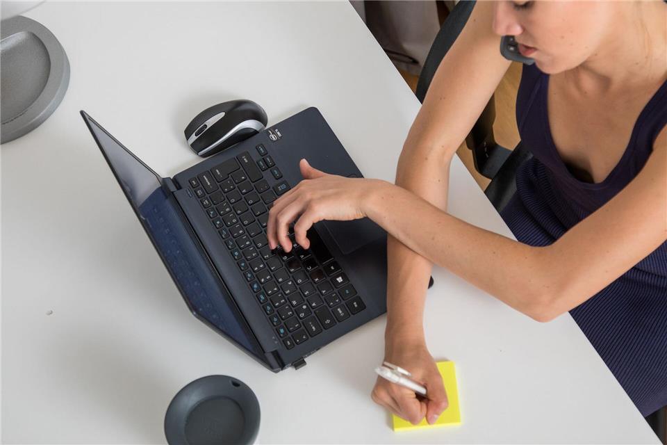 Eine negative Arbeitskultur verleitet dazu, Produktivität vorzutäuschen. Das zeigt sich etwa so, dass eine Kollegin telefoniert, gleichzeitig tippt und Notizen anfertigt. picture alliance / dpa-tmn
