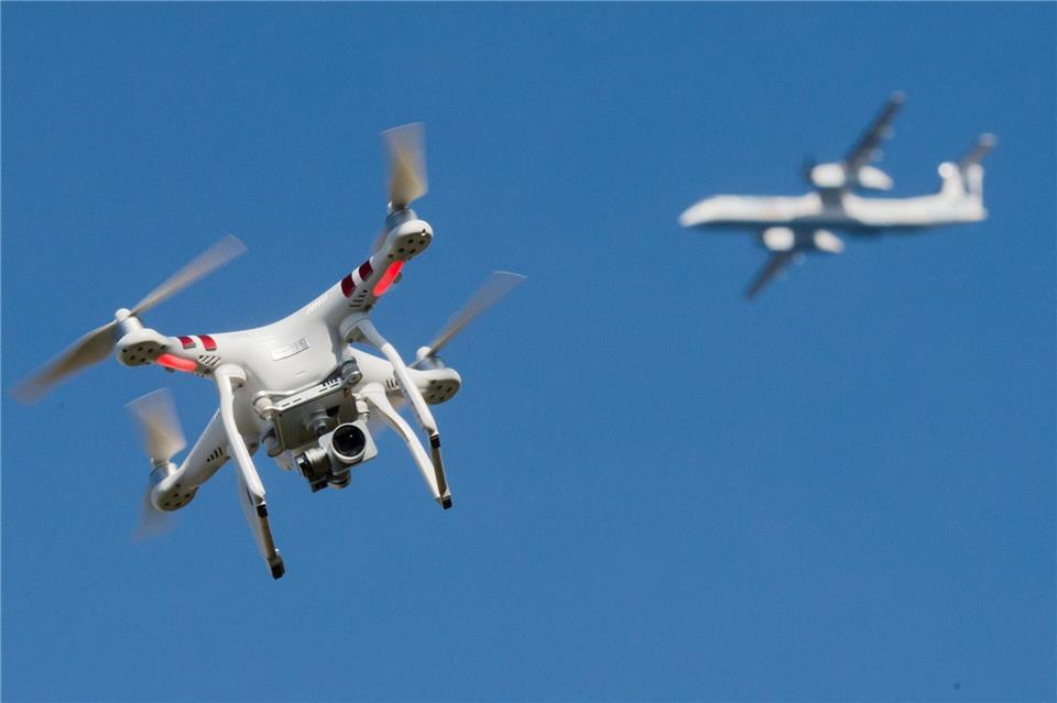 Eine private Drohne fliegt in weiter Entfernung von einem Flugzeug, das im Anflug auf den Flughafen Düsseldorf ist. (Symbolbild)Julian Stratenschulte/dpa