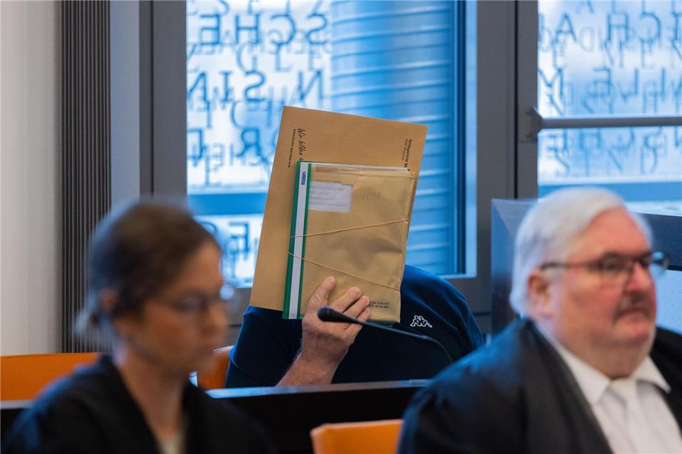 Einer der Angeklagten verdeckt sein Gesicht. (Archivbild)Rolf Vennenbernd/dpa