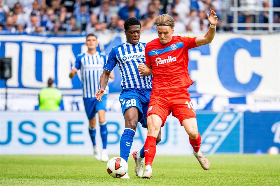 Einer von vielen Zweikämpfen im Spiel: Pierre Nadjombe (1. FC Magdeburg) und Jonas Therkelsen (r, Holstein Kiel) in Aktion.Julius Frick/dpa