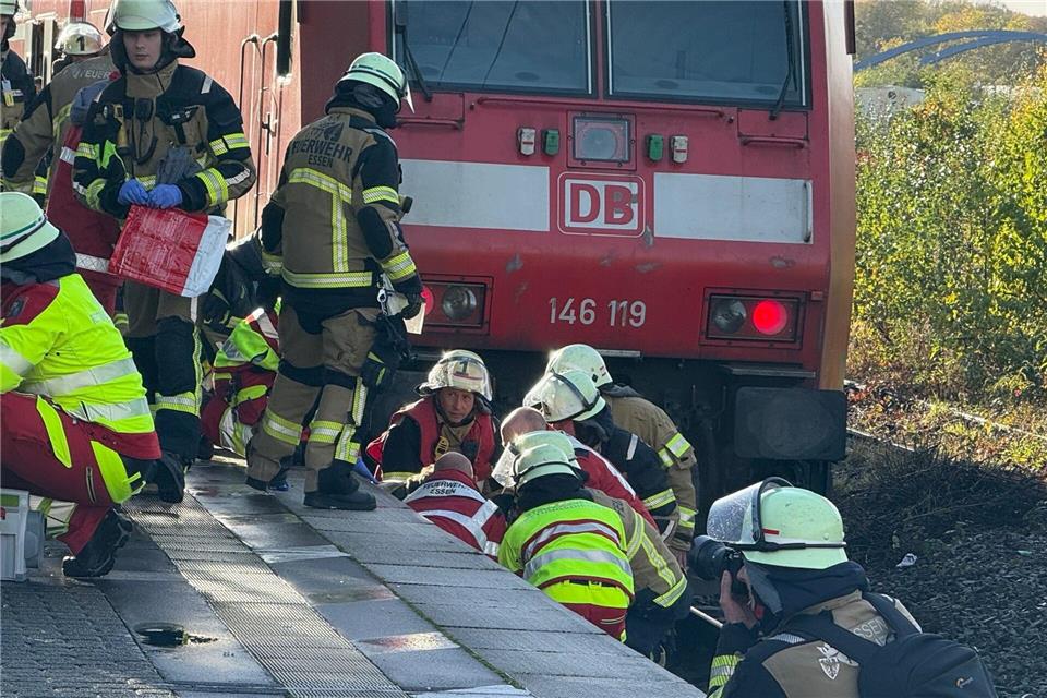 Mann stürzt aufs Gleis und wird von Zug erfasst - verletzt  Einsatzkräfte bergen den Verletzten - ein Mann ist in Essen auf Gleis gestürzt und von einem Zug erfasst worden. Stephan Witte/dpa