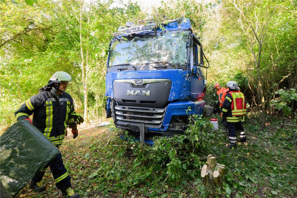 Einsatzkräfte der Feuerwehr stehen neben dem verunfallten Lkw an der Bundesstraße B3.Julian Stratenschulte/dpa