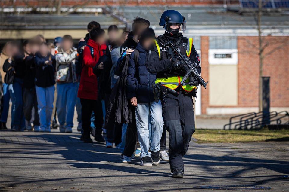 Entwarnung nach Amokalarm an Braunschweiger Gymnasium Einsatzkräfte der Polizei begleiten Schülerinnen und Schüler eines Braunschweiger Gymnasiums ins Freie. Moritz Frankenberg/dpa
